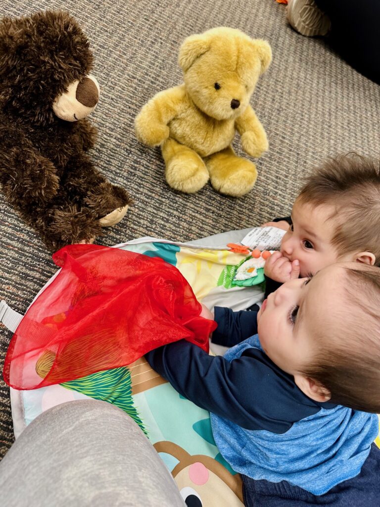 Twin boys in music class looking at bears